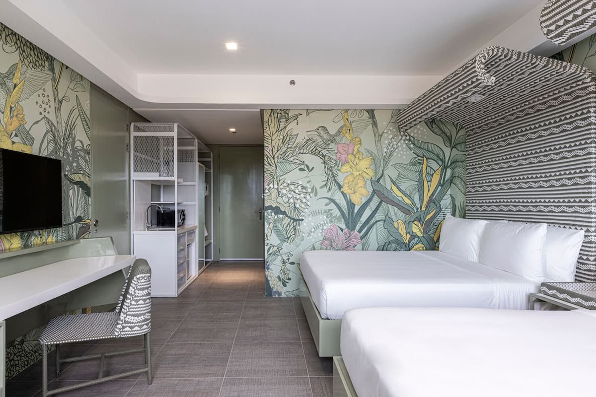 Una habitación de hotel con una cama, un escritorio y un televisor.