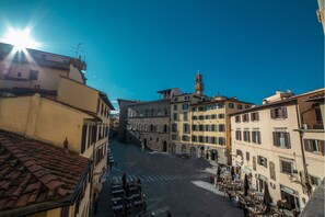 A square with buildings on either side, a tower, and outdoor seating areas. - B&B Galileo 2000 (Florence)