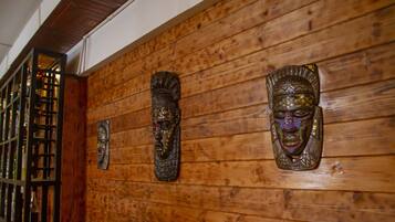 Wooden paneling with three carved masks on the wall.