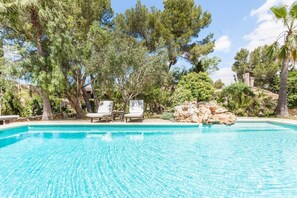 Alberca al aire libre y camastros