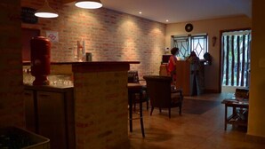 A cozy restaurant with brick walls, a bar area, and a dining space with chairs and tables. - Escambo Hostel (Sao Paulo)