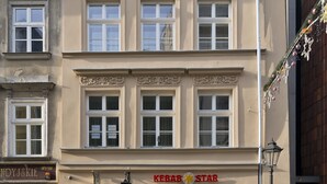 A building with a sign for 'Kebab Star' restaurant, featuring a classic architectural style with symmetrical windows and decorative moldings. - Aparthotel Grodzka 21 (Kraków)