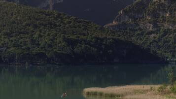 Un llac tranquil envoltat per turons verds i frondosos.
