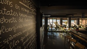 Interior de restaurante con un pizarrón que muestra un menú con diferentes platos y sus precios.