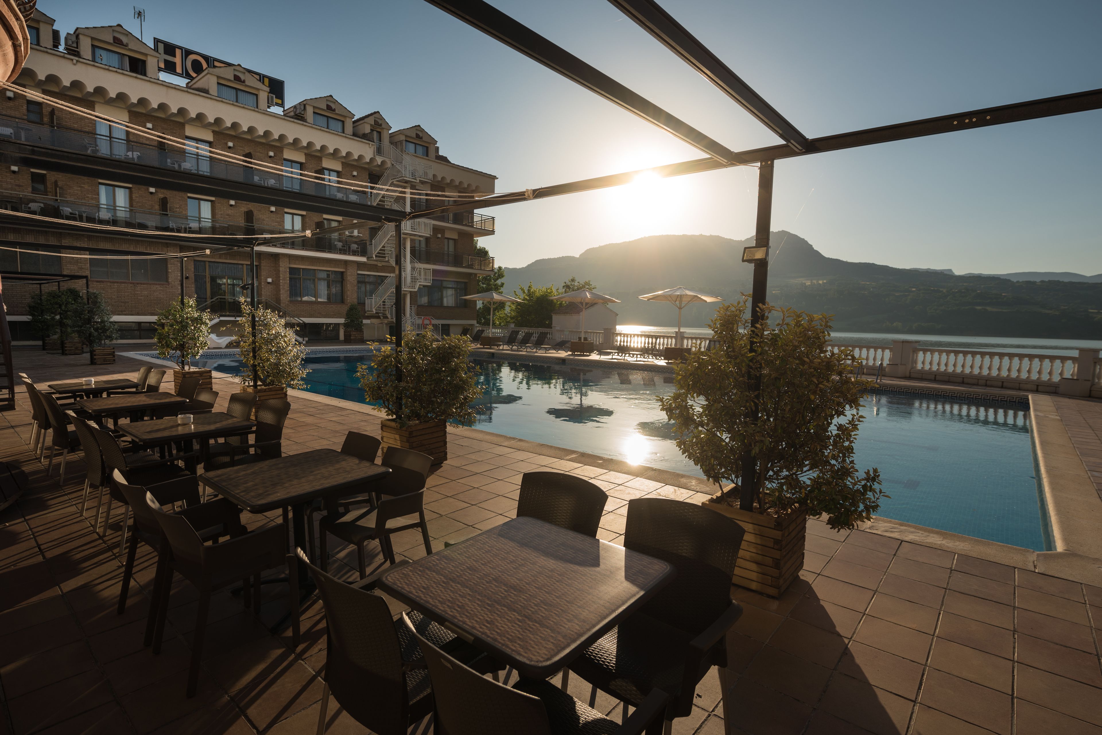 Una piscina al aire libre de temporada, sombrillas, tumbonas