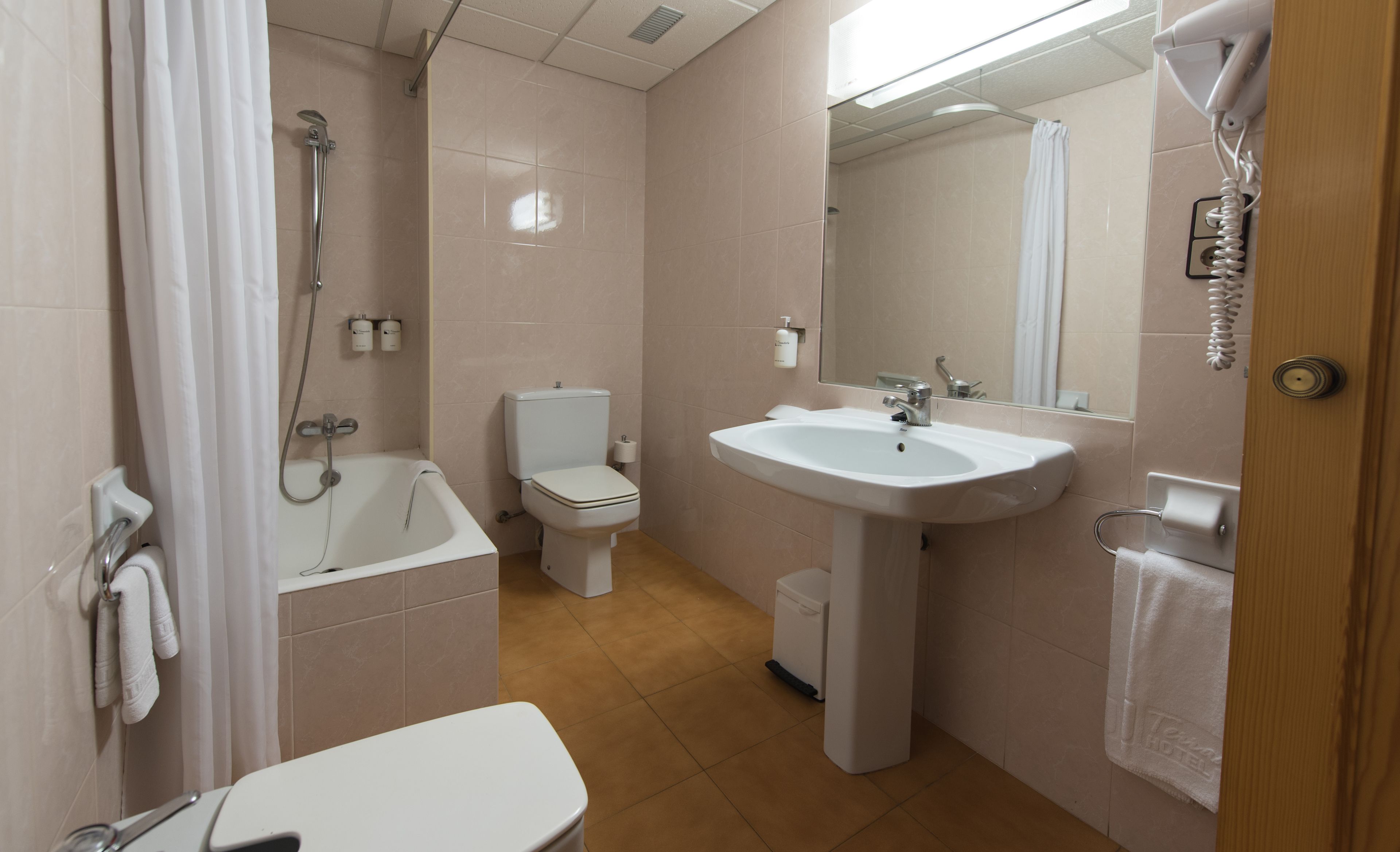 A bathroom with a bathtub, toilet, sink, and a shower.