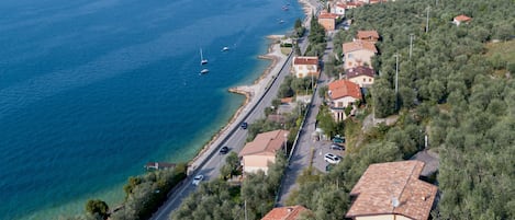 Vista aérea de un pueblo costero con casas, una carretera y un mar azul cristalino.