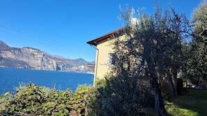 Un edificio costero con balcón que da a una masa de agua y acantilados.