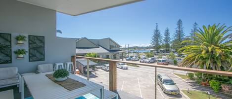 A balcony with a view of a parking lot and a building with a sign that reads "Auckland."
