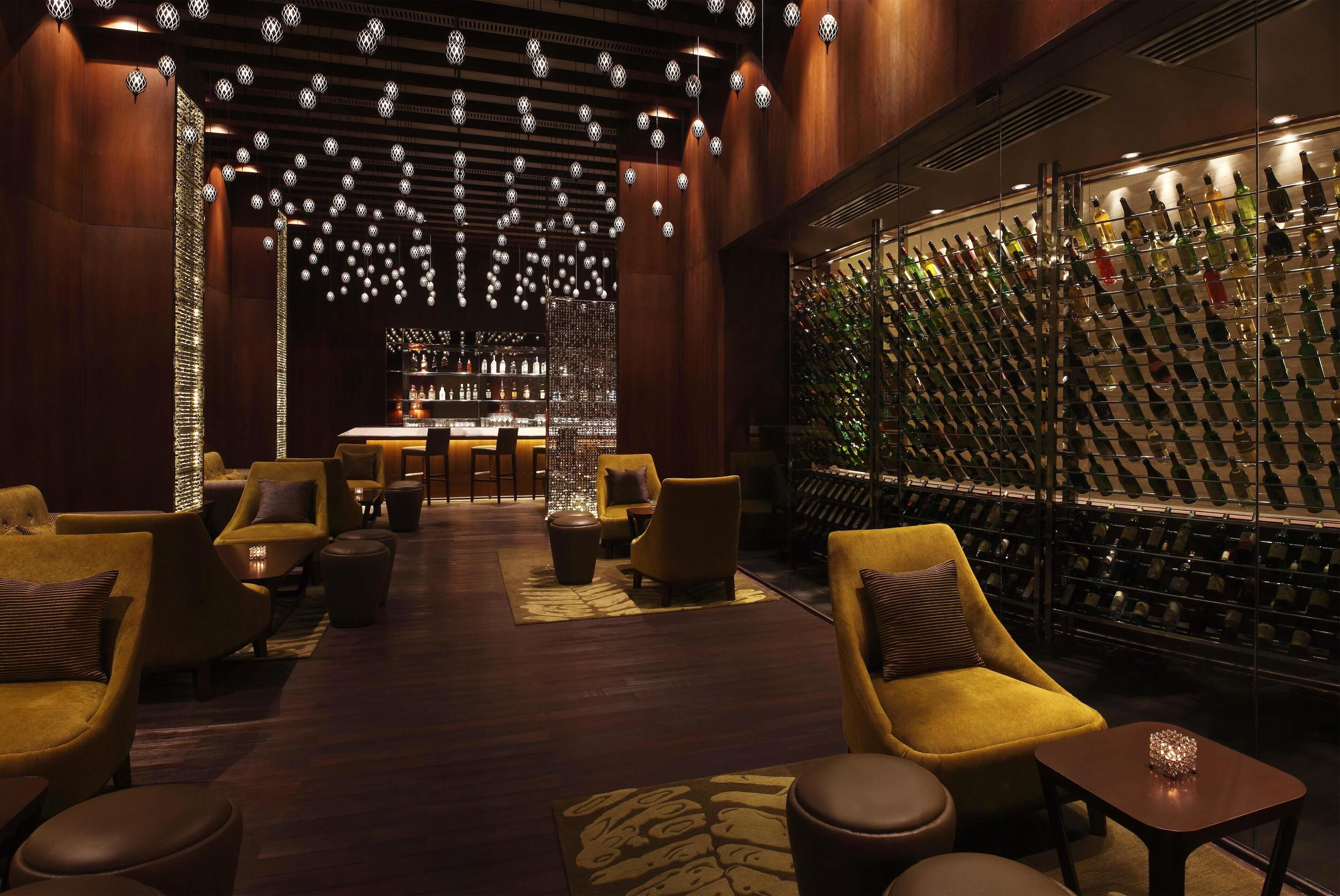 Zona de bar con estante para vinos y asientos.