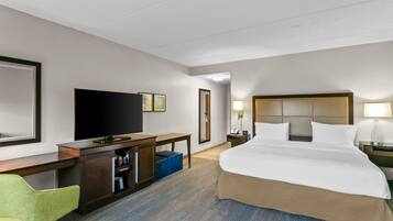 A hotel room with a bed, a desk, a television, and a chair.