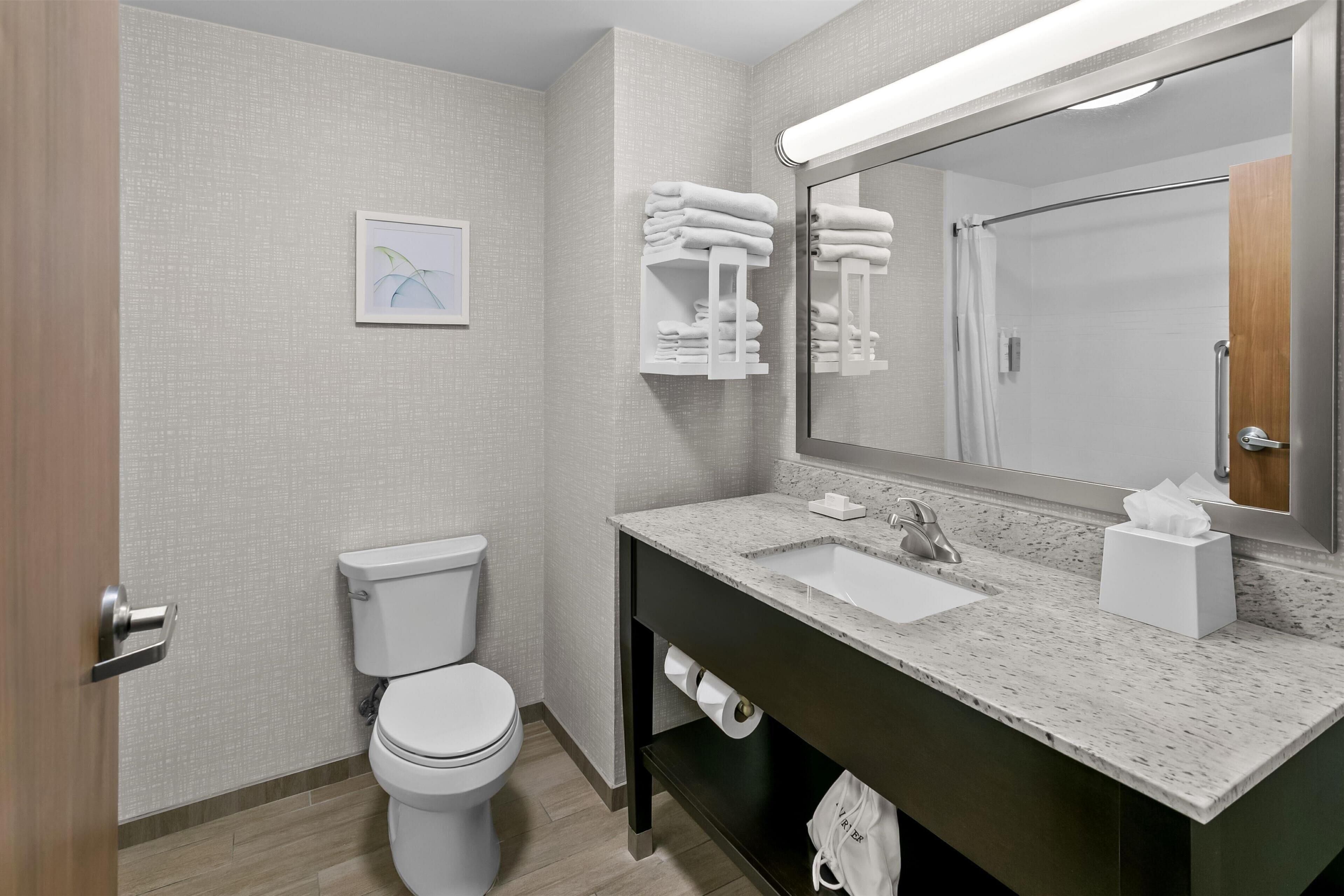 A modern bathroom with a toilet, sink, and towel rack.