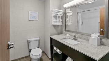 A modern bathroom with a toilet, sink, and towel rack.
