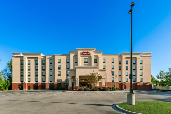 A large, multi-story hotel with a prominent entrance and a parking lot in front. - Hampton Inn & Suites Baltimore/Woodlawn (Windsor Mill)