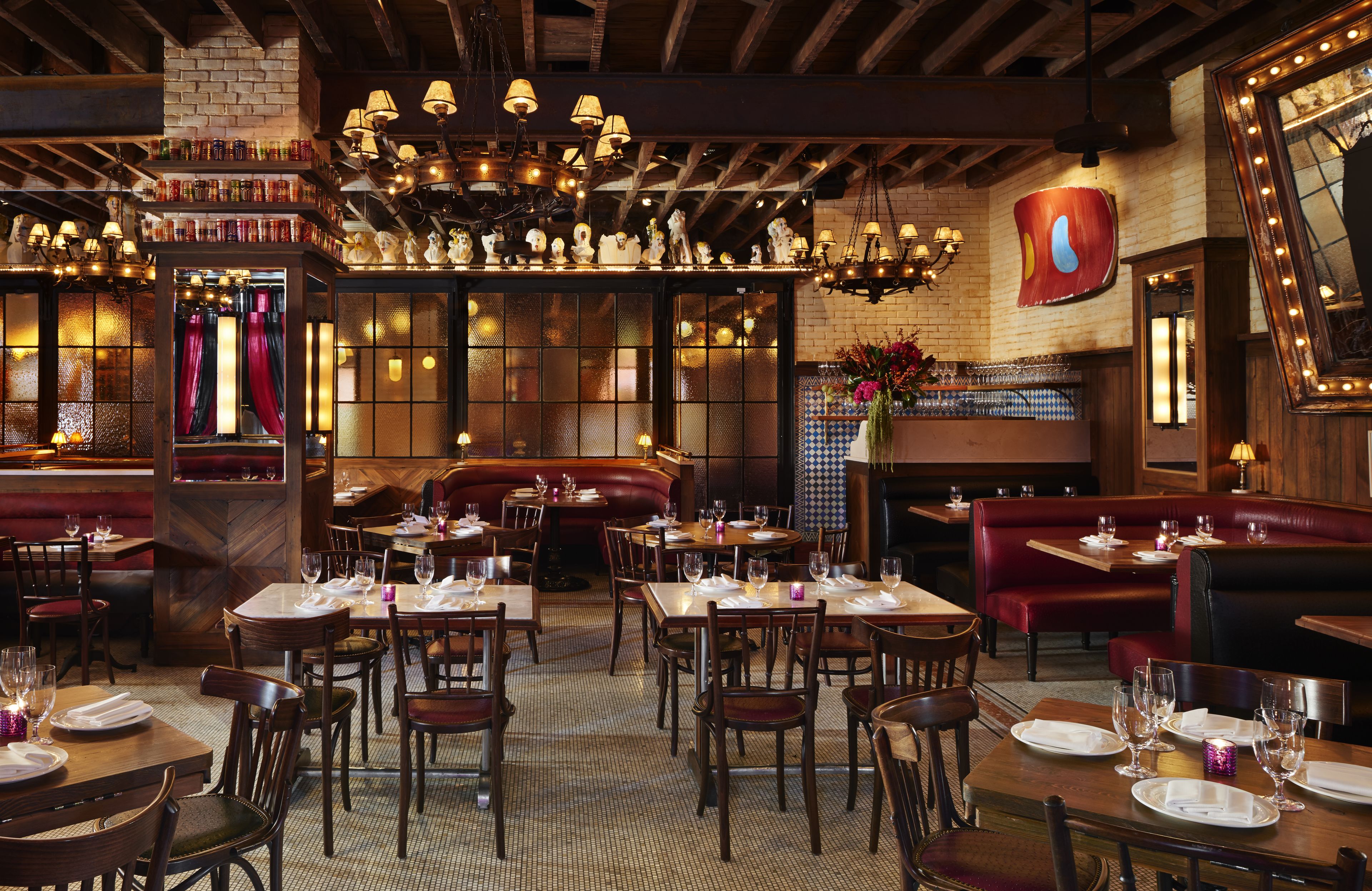 A restaurant interior with wooden tables, booths, and a brick wall.