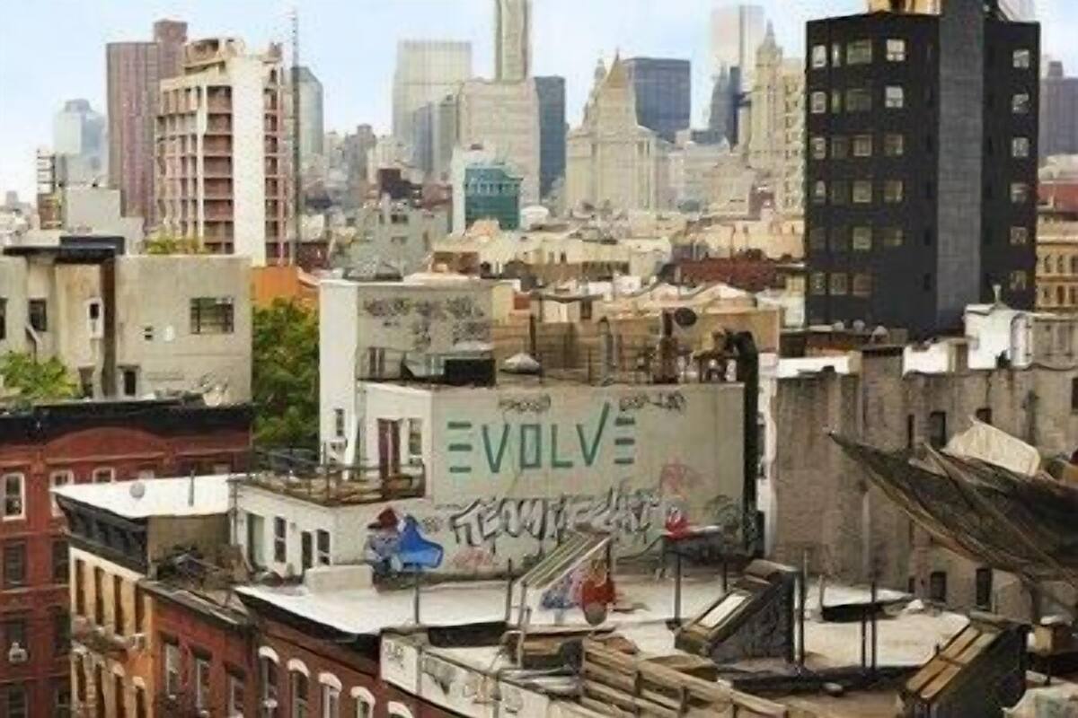 Un paisaje urbano con un edificio que muestra la palabra 'EVOLVE' en su lateral.