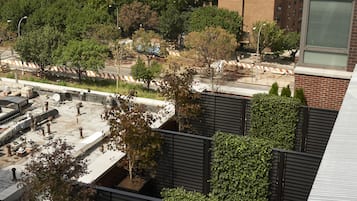 Un jardín en la azotea con plantas en macetas y una zona de estar.