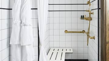 A bathroom with a shower, a bench, and a towel rack.