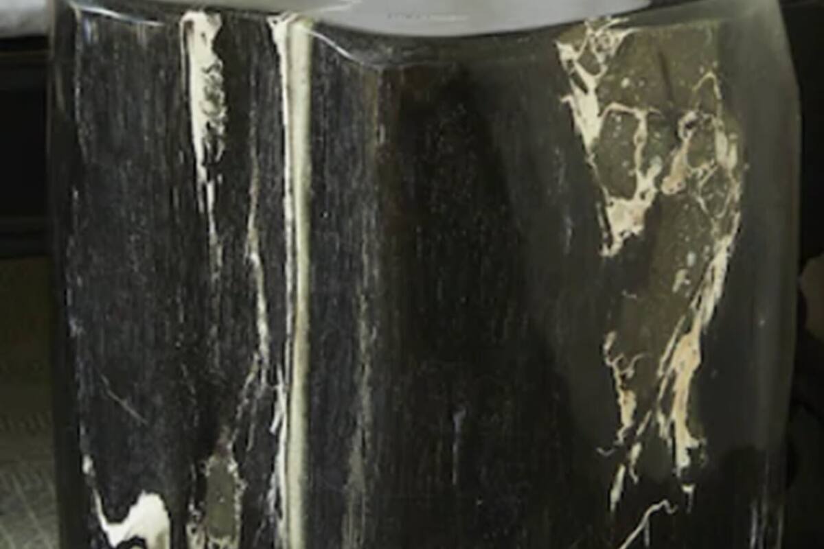 Una mesa de mármol negro con acabado brillante en una habitación de hotel.