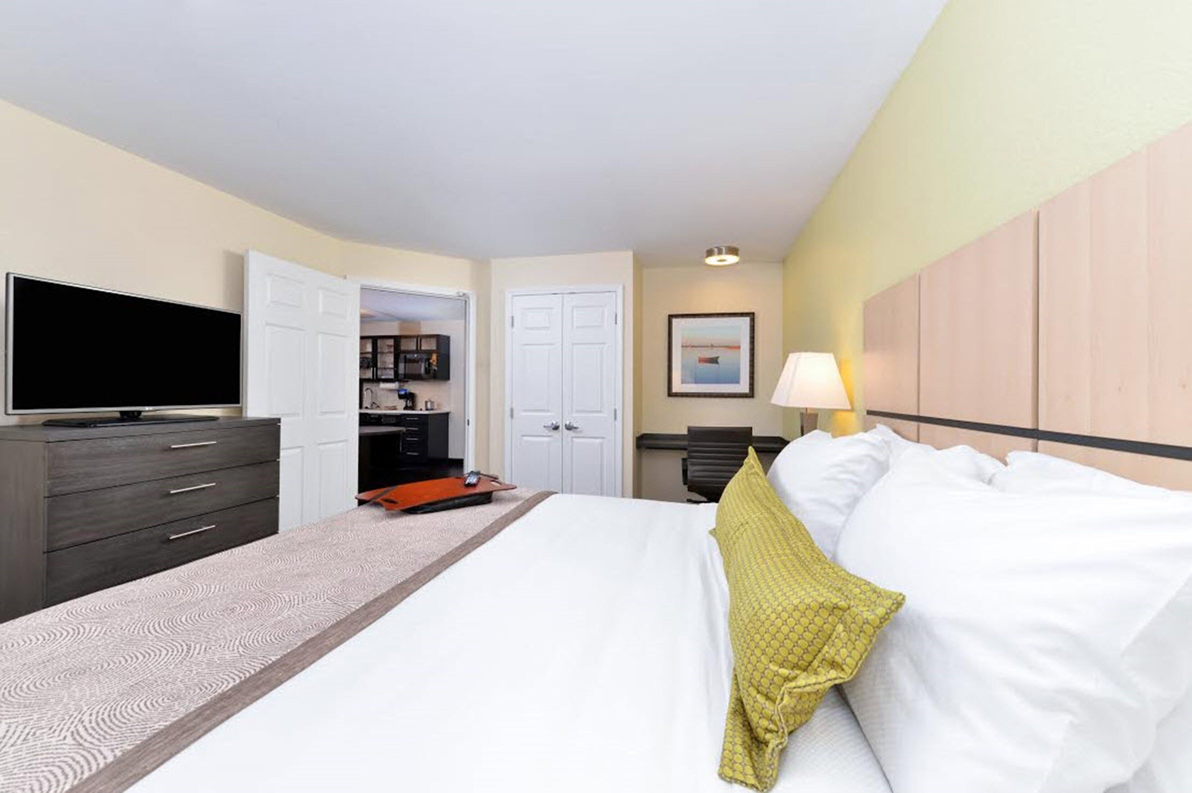 A hotel room with a bed, a TV, a desk, and a wardrobe.