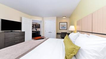 A hotel room with a bed, a TV, a desk, and a wardrobe.