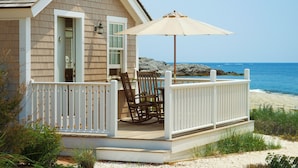 A coastal house with a deck, a rocking chair, and a beach view. - Castle Hill Inn (Newport)