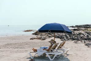 Praia particular, espreguiçadeiras, guarda-sóis, toalhas de praia 