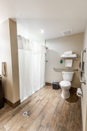 A bathroom with a toilet, a shower curtain, a towel rack, and a trash bin. - Homewood Suites by Hilton Charlotte Ballantyne, NC (Charlotte)