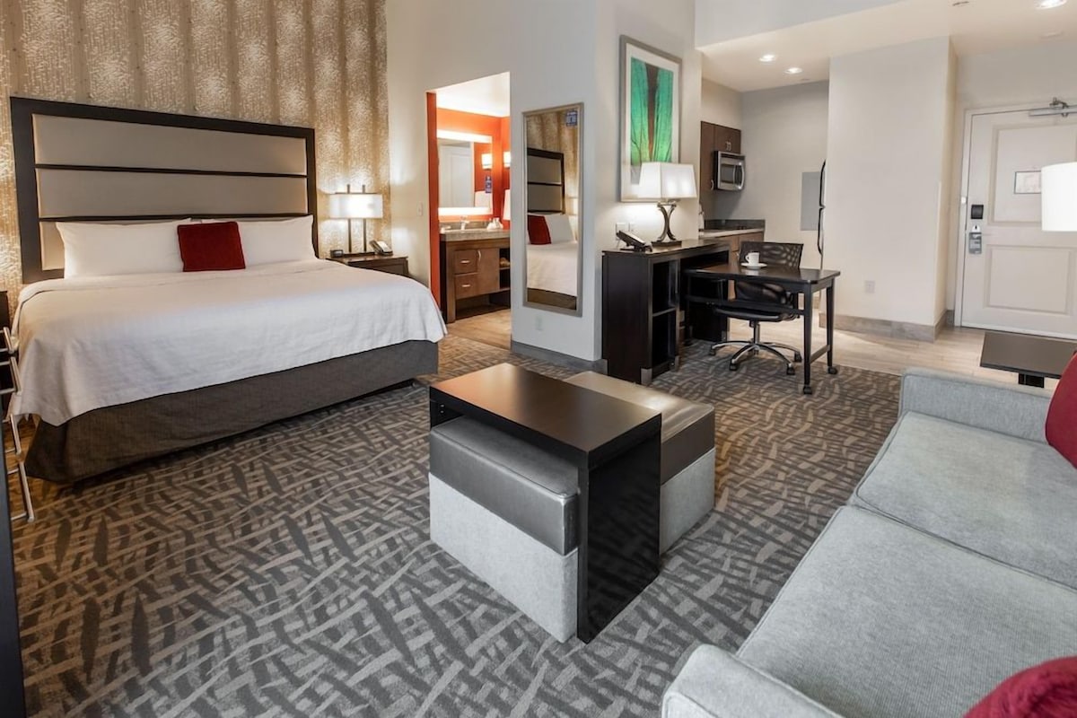 Une chambre d’hôtel avec un lit, un bureau, un canapé et une petite table.