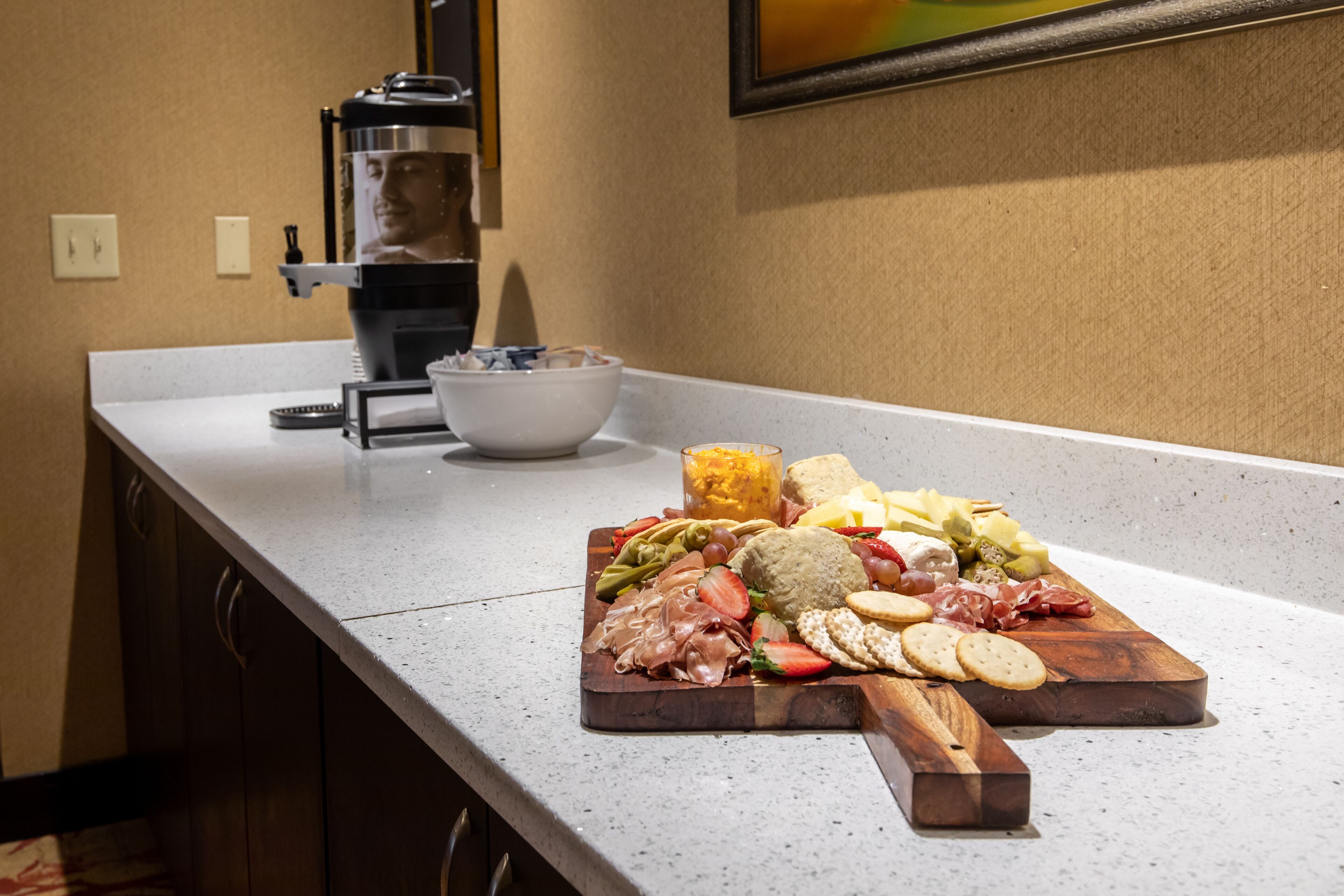 A kitchen counter with a charcuterie board featuring various meats, cheeses, and crackers.