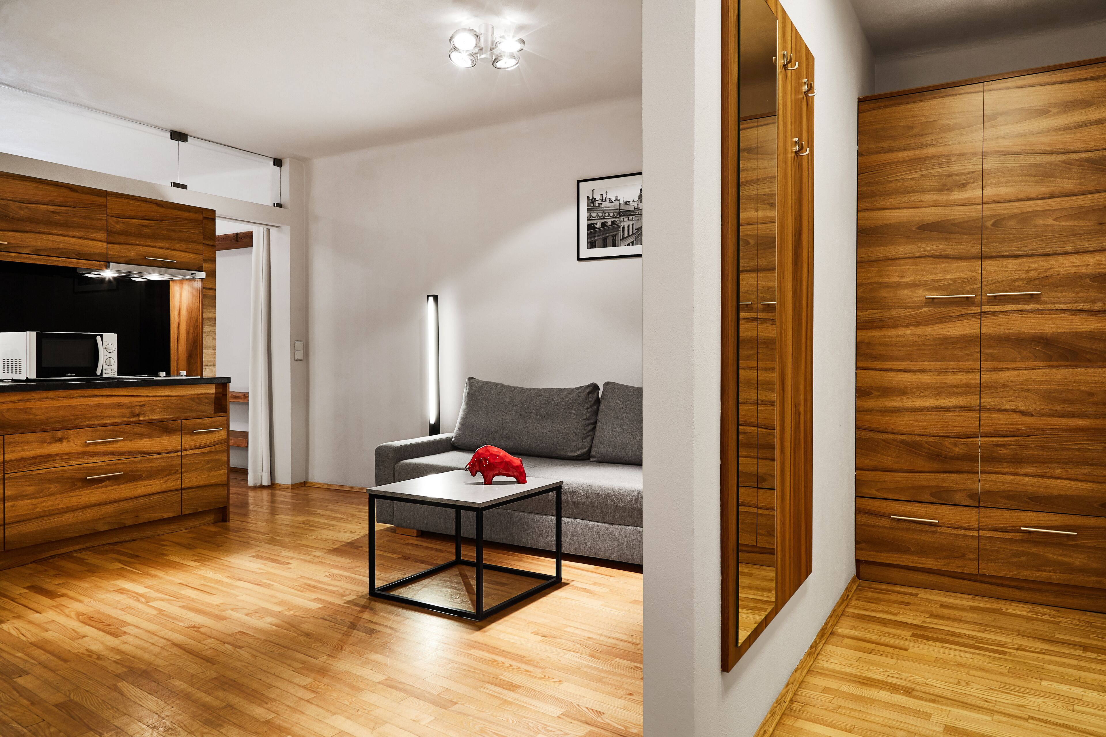 A modern living room with a wooden cabinet, a grey sofa, and a small table.