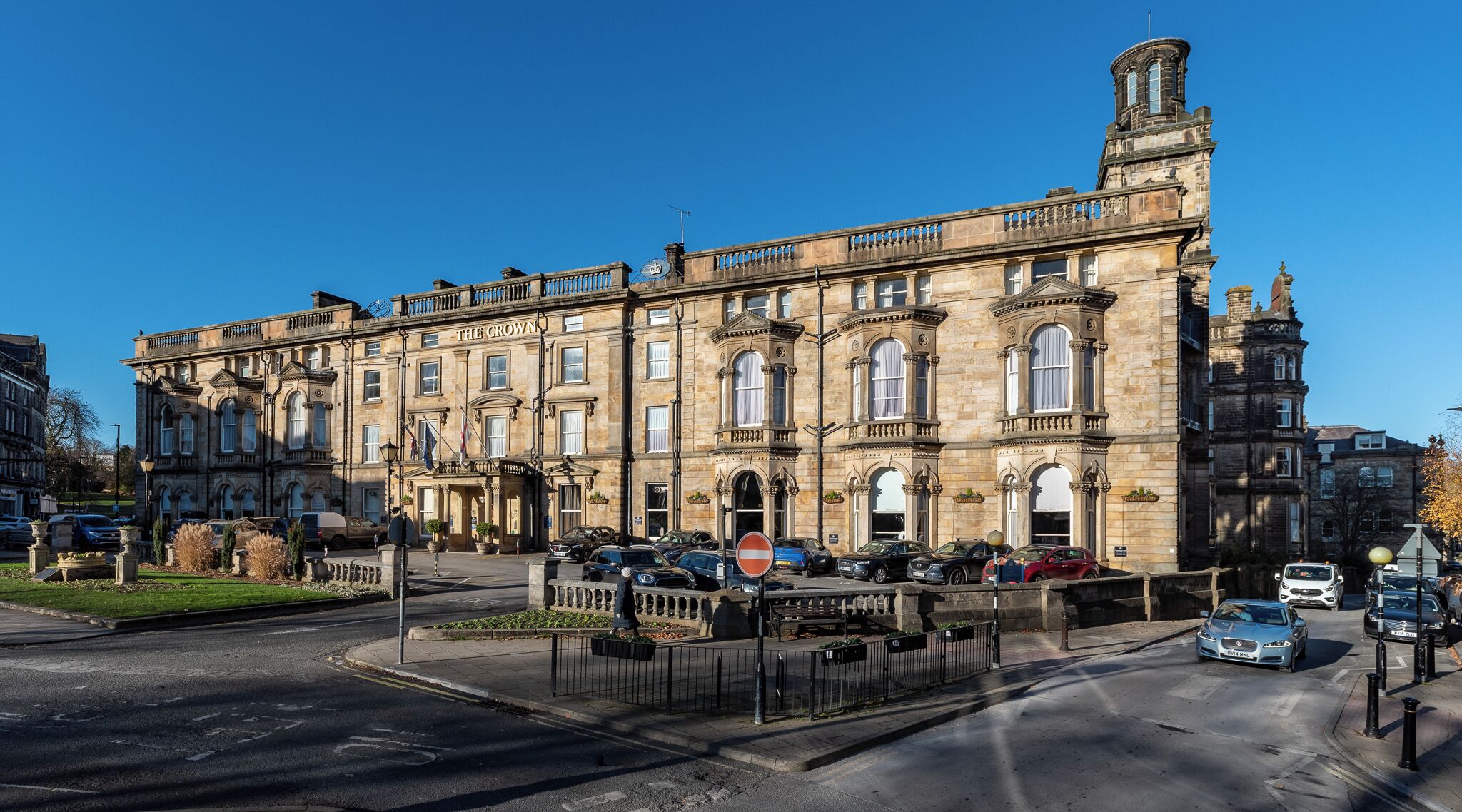 A historic building with a prominent corner tower, multiple windows, and a well-maintained entrance area.