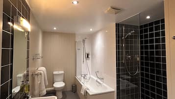 A modern bathroom with a glass-enclosed shower, a white sink, and a toilet.