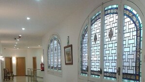 A hallway with arched windows, a trash bin, and a staircase. - Hostal Buenos Aires (Madrid)