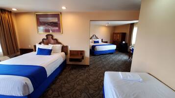 A hotel room with two beds, a large mirror, and a carpeted floor.