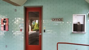 A teal-tiled wall with a red door labeled "OFFICE". - Colony Inn (North Hollywood)