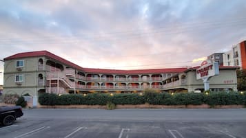 Experience the classic charm of the Colony Inn, featuring a flat facade and central entrance, surrounded by a well-maintained garden.