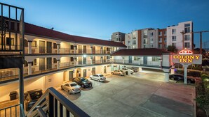 A multi-story motel with a parking area, balconies, and a neon sign for Colony Inn. - Colony Inn (North Hollywood)