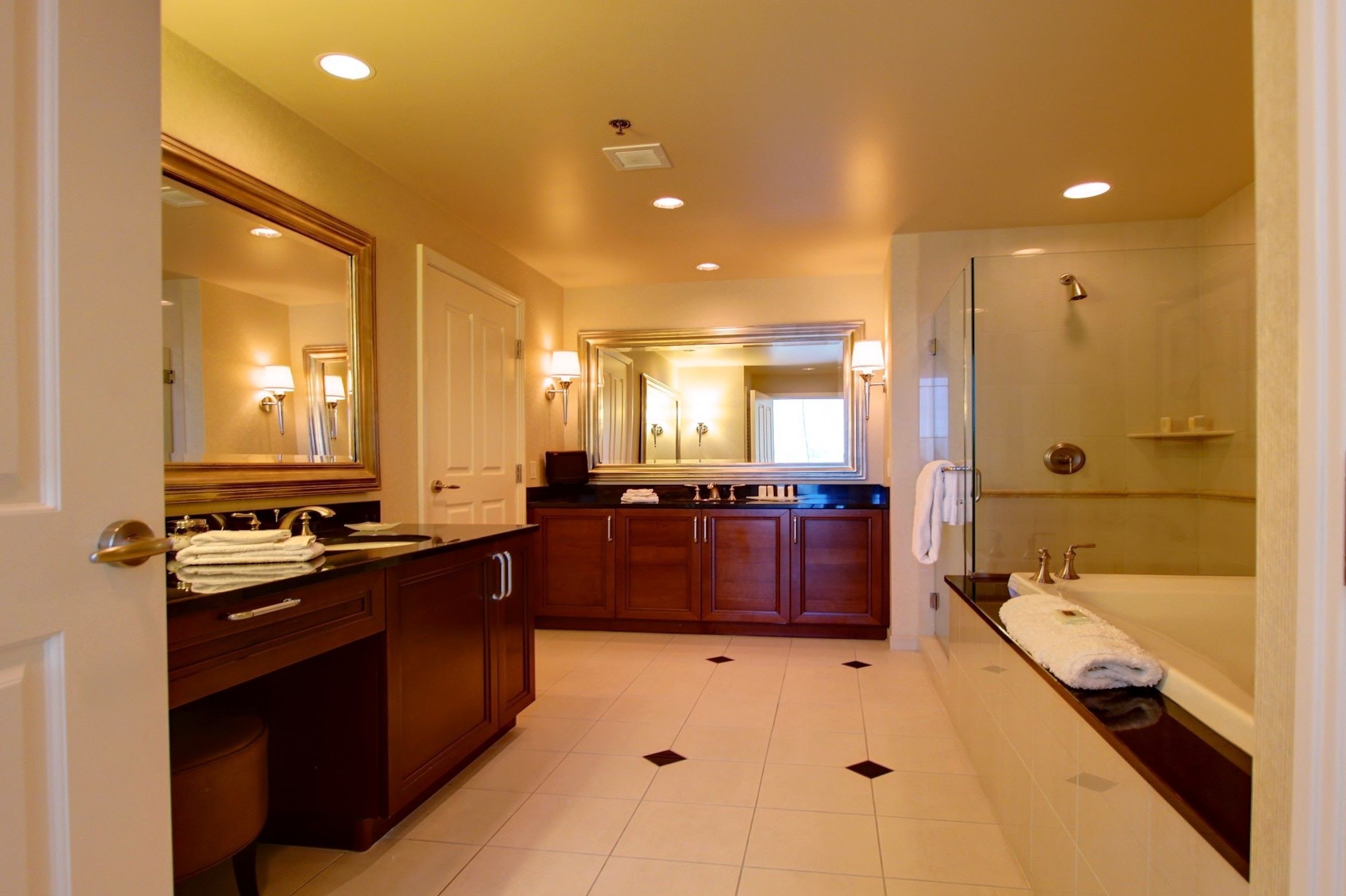 A spacious bathroom with a large mirror, a bathtub, and a shower area.