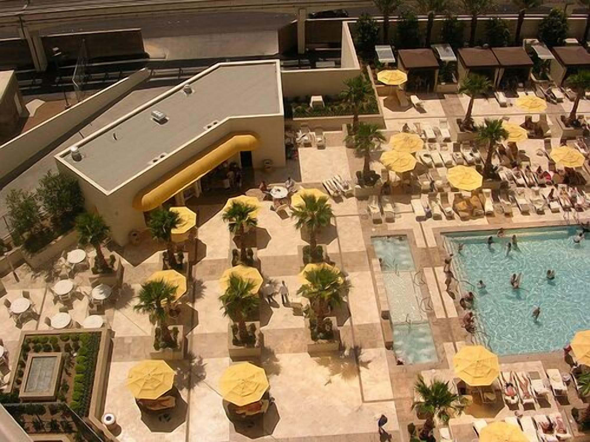 An aerial view of a resort with multiple pools, sun loungers, and umbrellas.