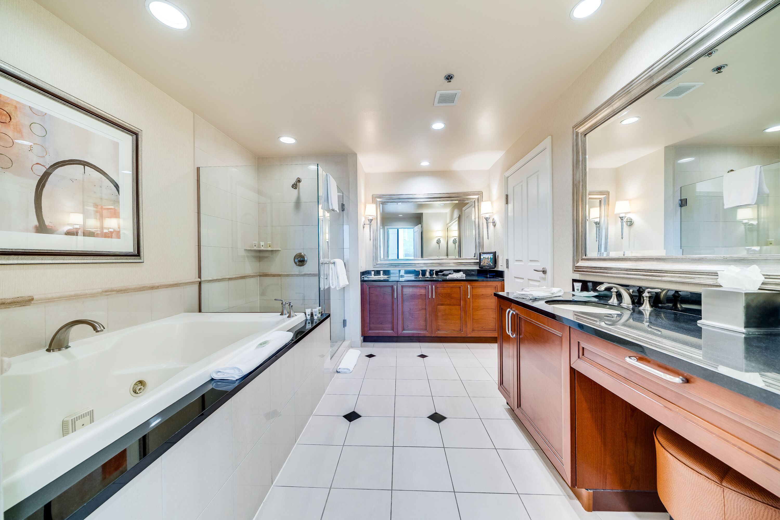 A modern bathroom with a large bathtub, a separate shower area, and a vanity with a mirror.