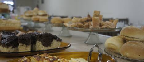 A buffet with various baked goods including cakes and pastries.