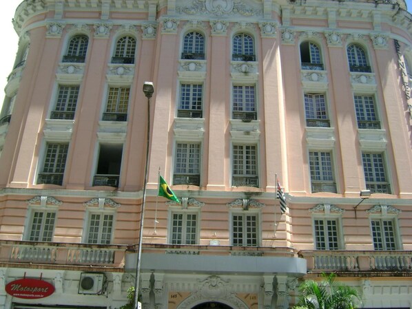 A large, pink building with multiple windows and a flag. - Reinales Plaza Hotel (Sao Paulo)