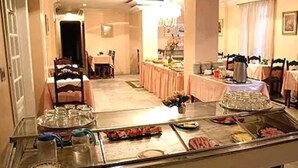 A hotel dining area with a buffet setup, including a variety of food items and a coffee station.