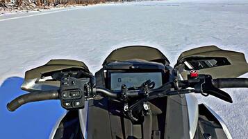 A snowmobile on a frozen lake with a clear sky.