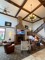 A living room with a fireplace, a television, and a staircase.