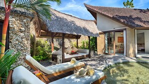 A resort with a pool, a thatched-roof structure, and a modern building with large windows. - Villa Kubu, Seminyak (Seminyak)