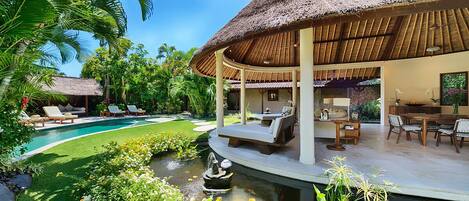 Um resort com piscina, espreguiçadeiras, área de refeições e um alpendre coberto.