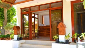 A building with a wooden facade, large glass doors, and steps leading to a covered entrance. - The Sitio Boracay Villas and Suites (Boracay Island)