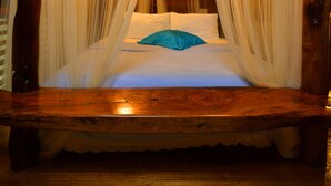 A wooden four-poster bed with white drapes and a blue pillow. - The Sitio Boracay Villas and Suites (Boracay Island)